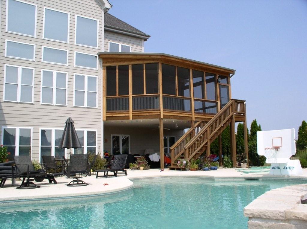 elevated screen room with staircase near pool