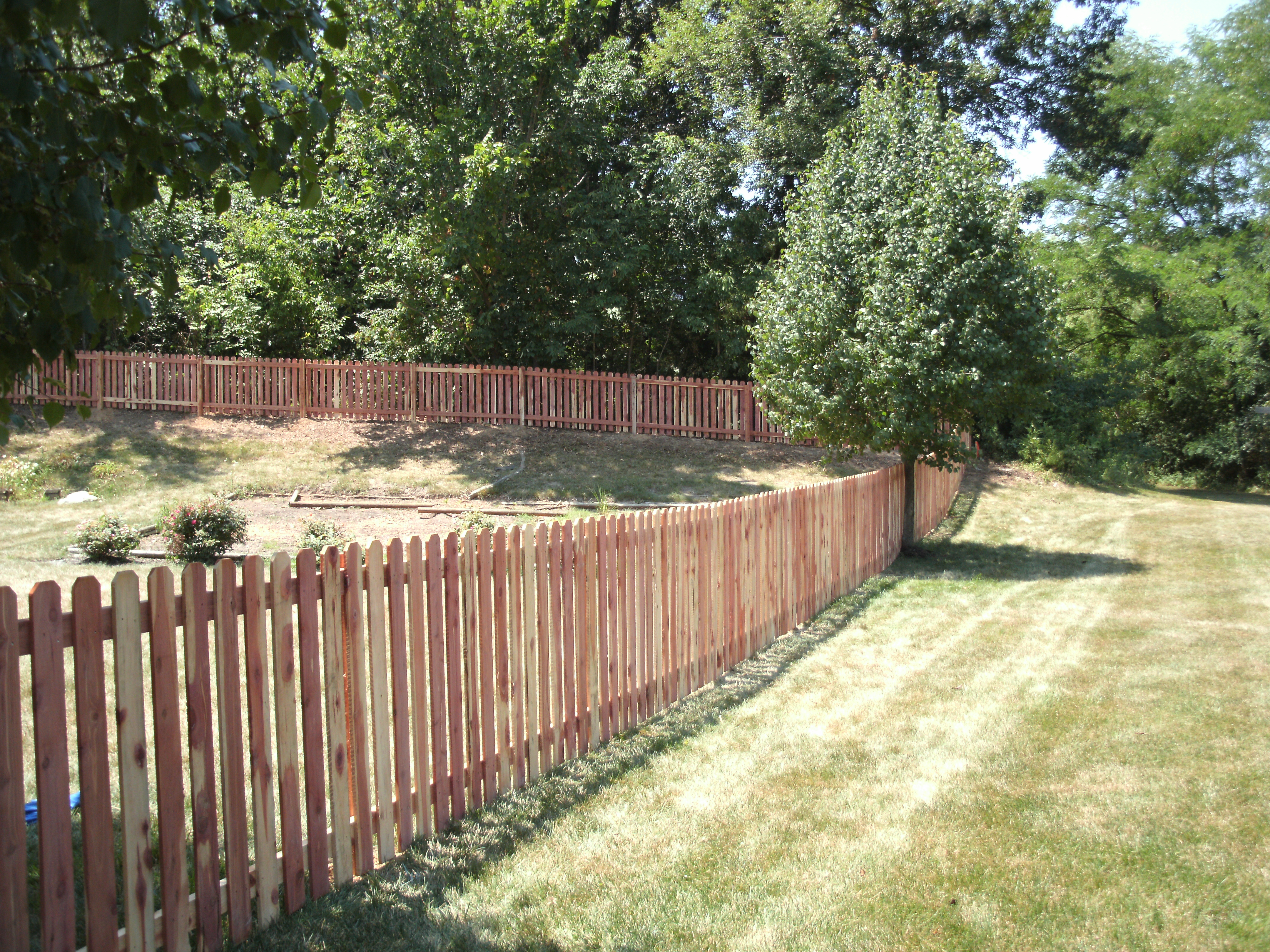 wood picket fence surrounding a yard