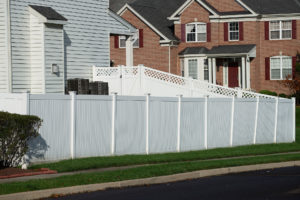 white vinyl fence with brick home in background