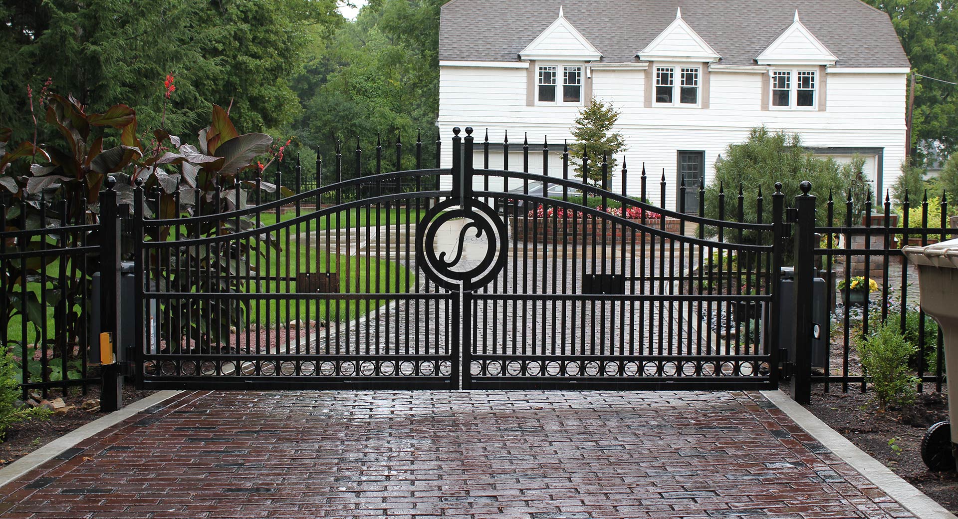 stylish aluminum gate crossing brick driveway