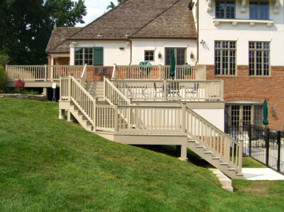Khaki deck with staircase on a brick and white house
