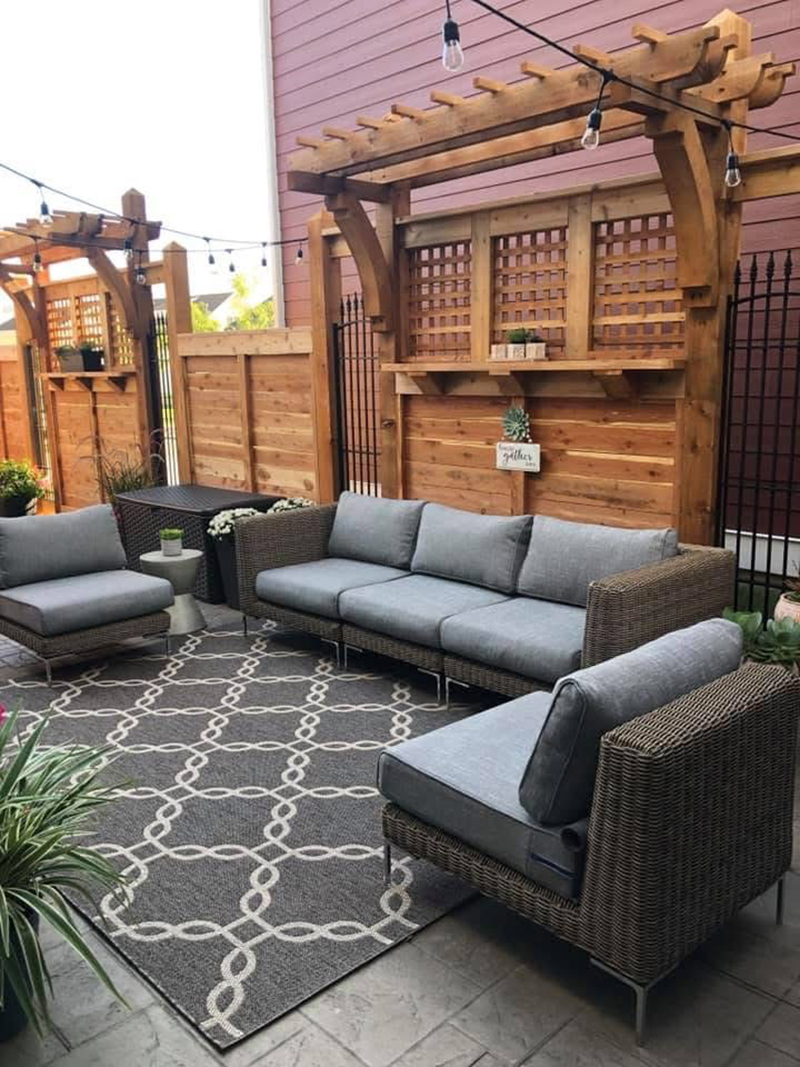 Wood pergola built into the fence surrounding an outdoor seating space