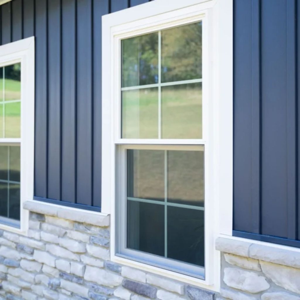 Beautiful white window on a blue and stone house