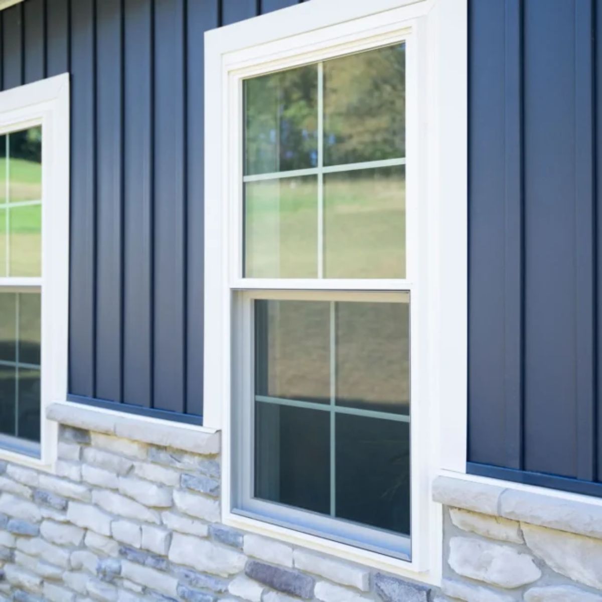 Beautiful white window on a blue and stone house