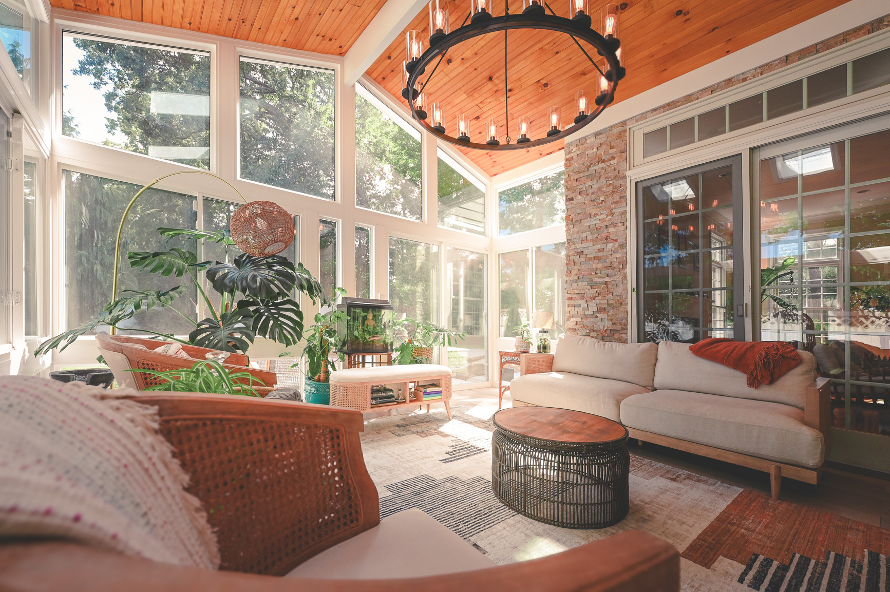 Living space sunroom with tall wood ceilings and large windows