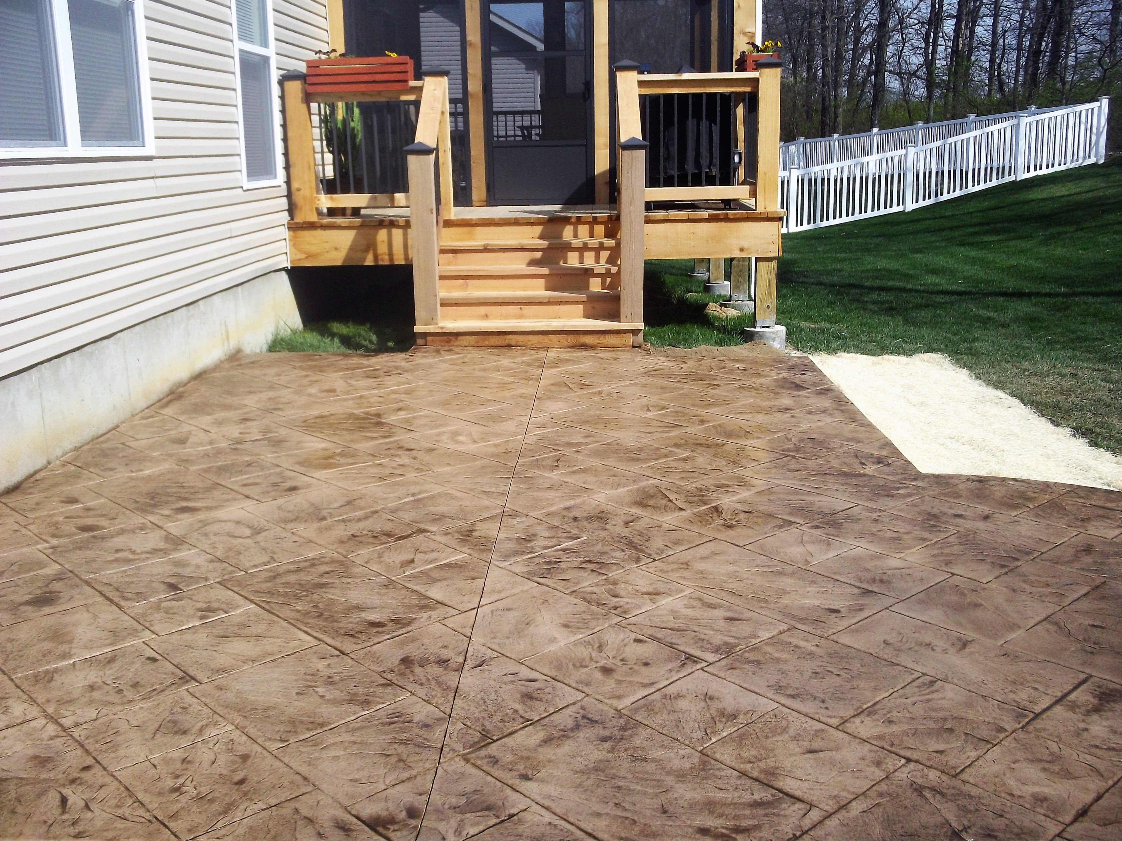 Stamped concrete patio leading up to a screened deck