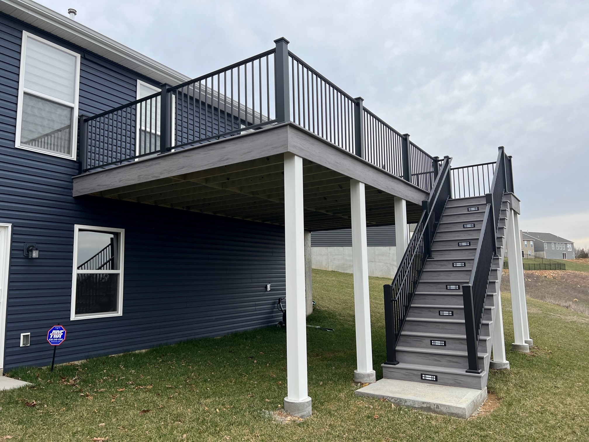 Gray deck with black railings and white posts