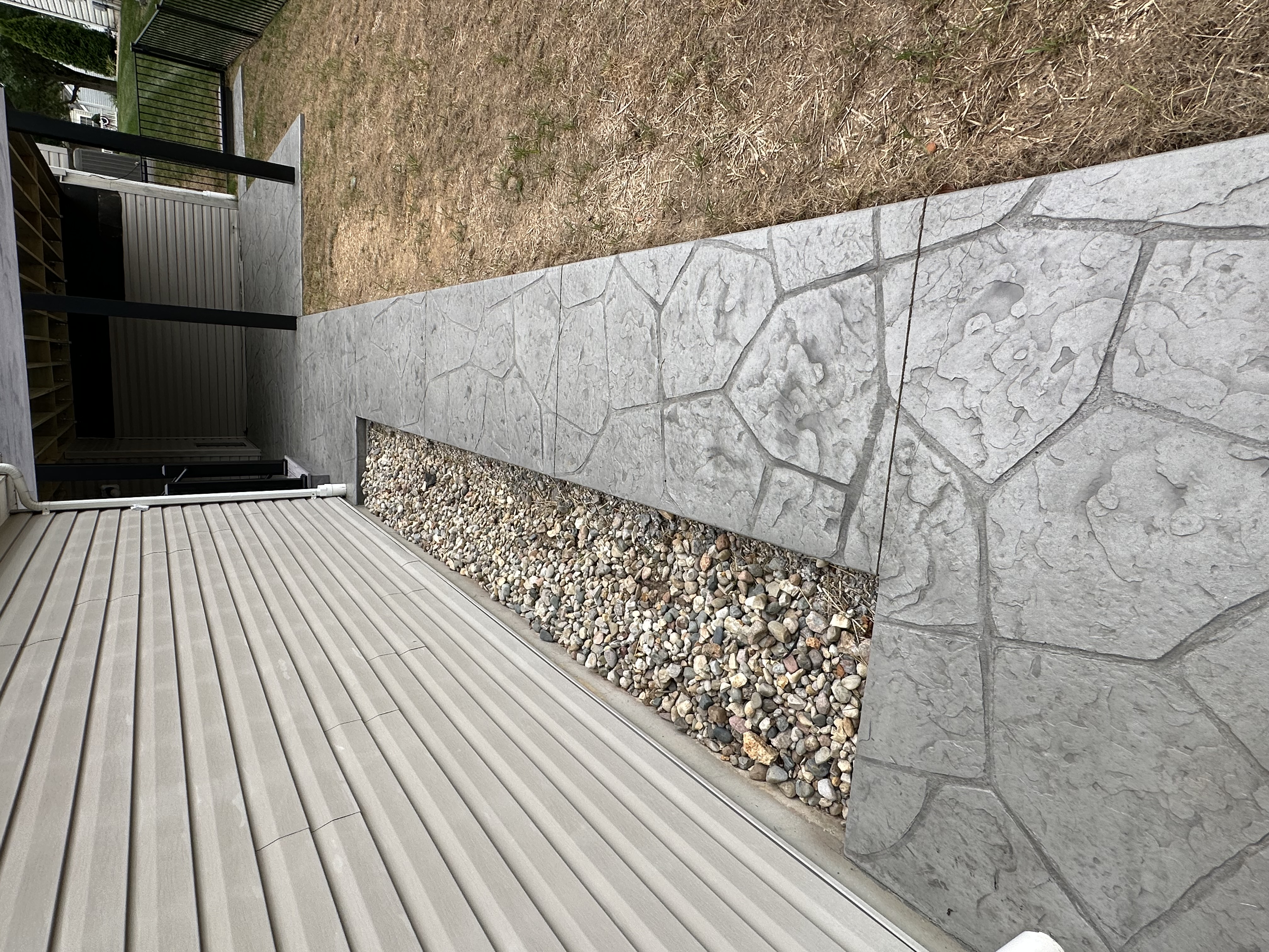 Stamped concrete pathway on the side of a home