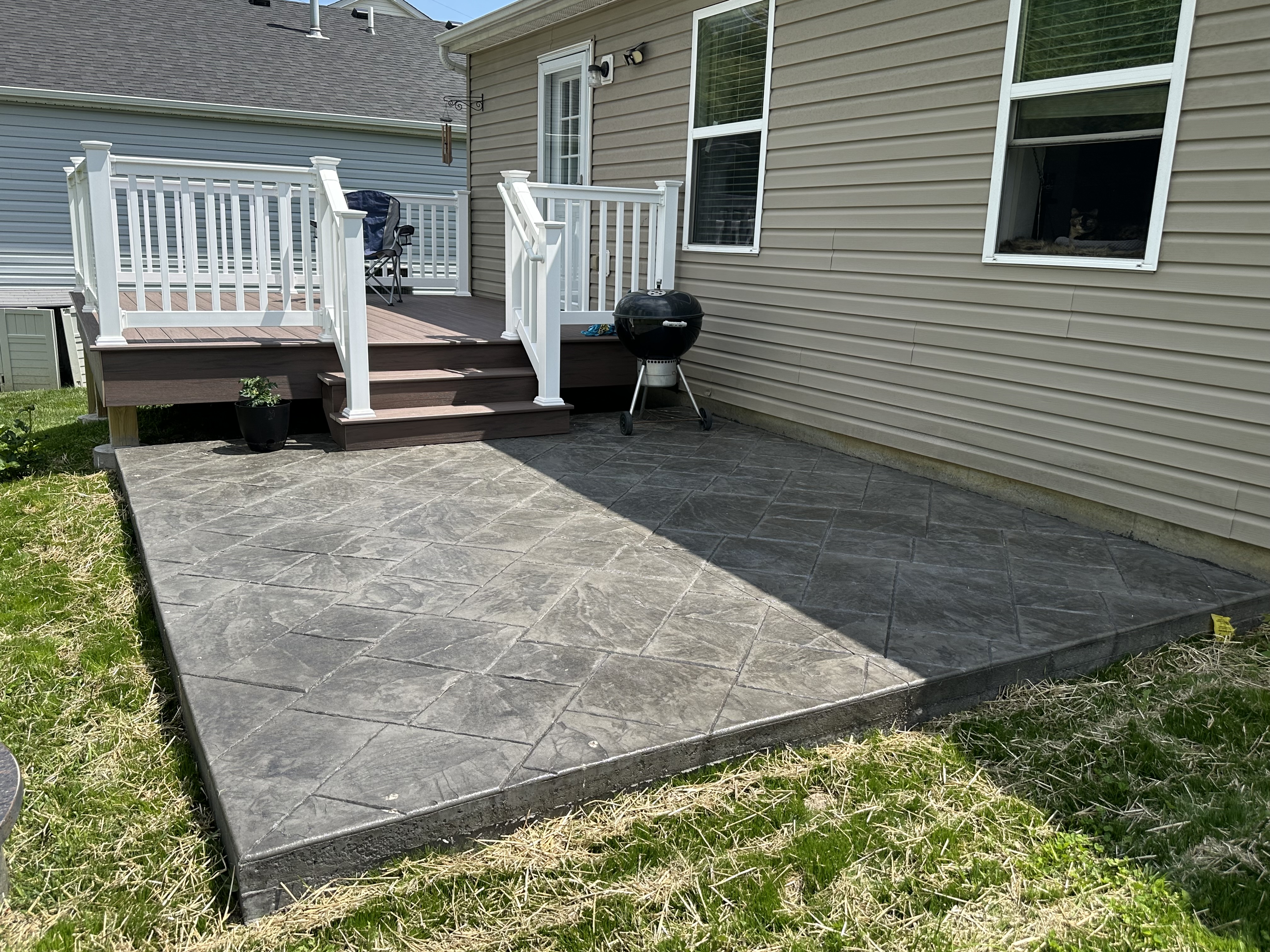 Gray geometric stamped patio below a vinyl deck in St. Louis