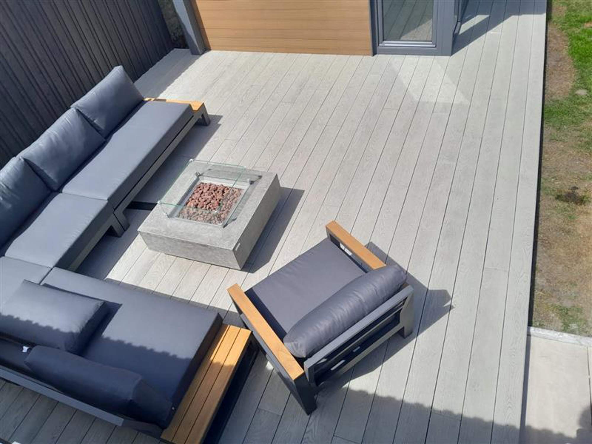 Outdoor living space with couch seating on millboard decking