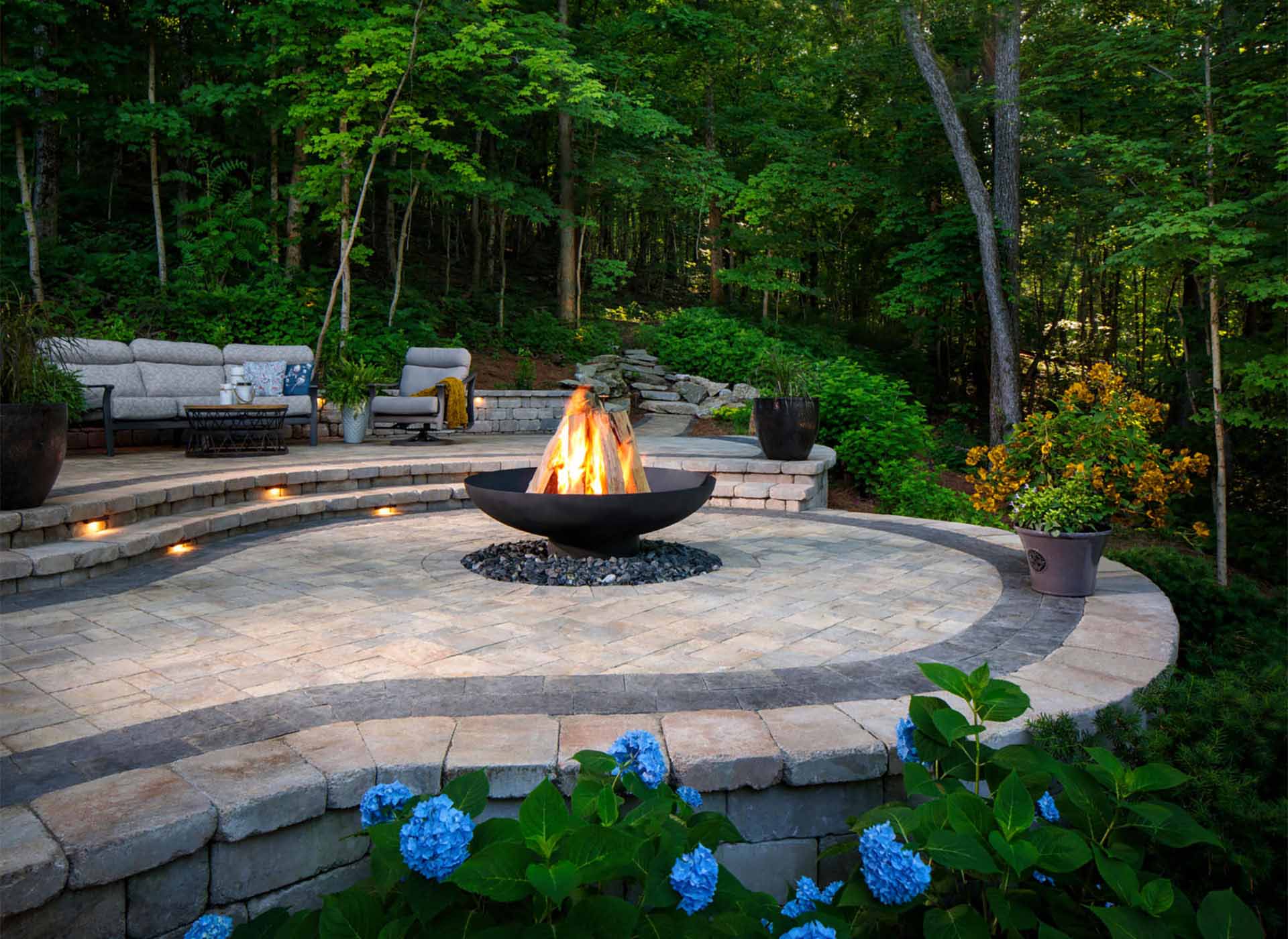 Circular shaped paver patio with a firepit in an outdoor living space
