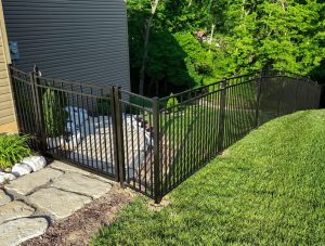 Aluminum Fence with gate going down a hill with a stone walkway.